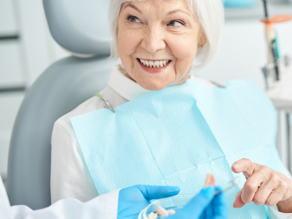 Mature woman sitting in dental chair for denture assessment.